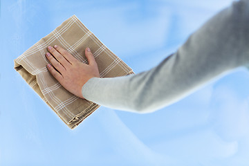 Image showing close up of woman hand cleaning window with cloth