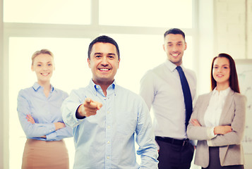 Image showing businessman in office pointing finger at you