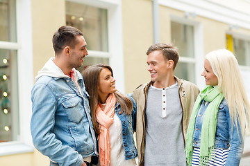 Image showing group of smiling friends walking in the city