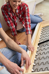 Image showing close up of couple assembling furniture at home