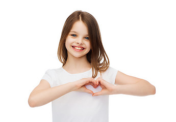 Image showing smiling little girl showing heart with hands