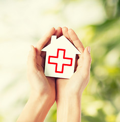 Image showing hands holding paper house with red cross