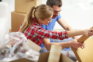 Image showing close up of couple unpacking furniture and moving