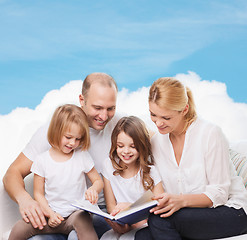 Image showing happy family with book at home