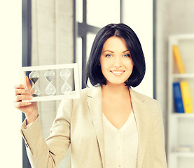 Image showing businesswoman holding hourglass