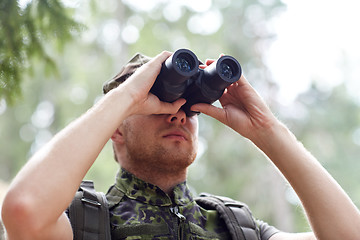 Image showing young soldier or hunter with binocular in forest