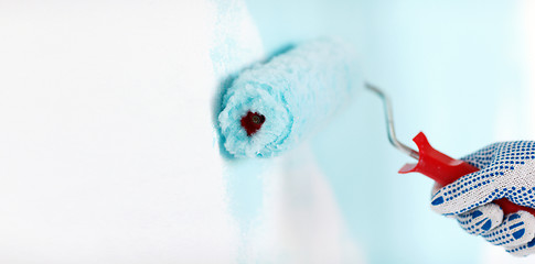 Image showing close up of male in gloves painting wall