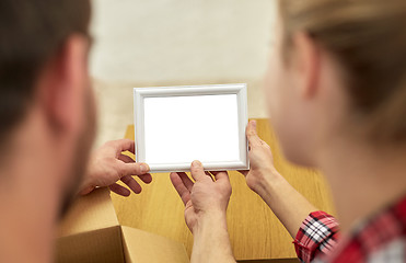 Image showing close up of happy couple looking at family photo