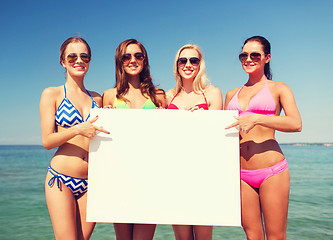 Image showing group of smiling women with blank board on beach