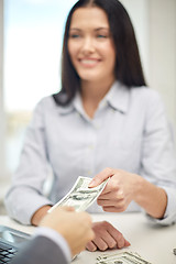 Image showing close up of happy woman giving or exchanging money