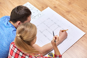 Image showing close up of couple with  blueprint at home