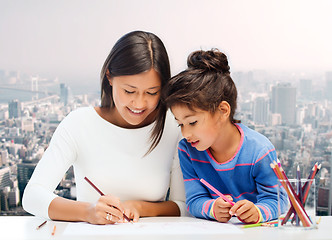 Image showing happy mother and daughter drawing with pencils