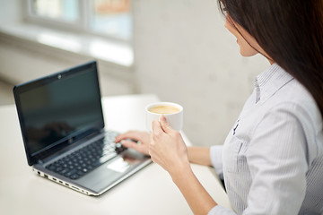 Image showing close up of woman with laptop drinking coffee