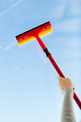 Image showing close up of hand cleaning window with sponge