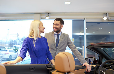 Image showing happy couple buying car in auto show or salon