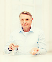 Image showing old man with pills ang glass of water