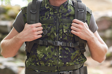 Image showing close up of young soldier with backpack in forest