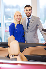 Image showing happy couple buying car in auto show or salon