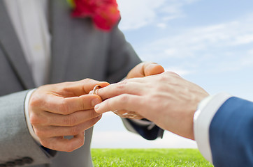 Image showing close up of male gay couple hands and wedding ring