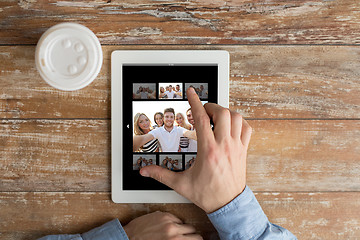 Image showing close up of male hands with photo on tablet pc