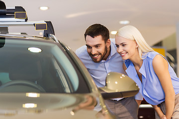 Image showing happy couple buying car in auto show or salon