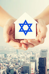 Image showing close up of hands holding house with star of david