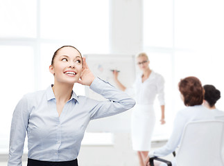 Image showing smiling businesswoman listening gossig