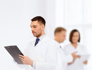 Image showing serious male doctor with clipboard