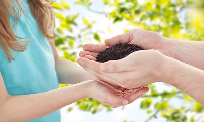 Image showing close up of father and girl hands holding sprout