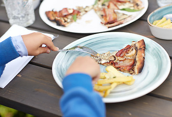 Image showing close up of child hands having dinner outdoors