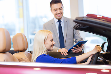 Image showing happy woman with car dealer in auto show or salon