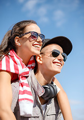 Image showing smiling teenagers in sunglasses having fun outside