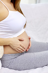 Image showing close up of pregnant woman with bare tummy at home