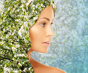 Image showing young woman face over blooming tree pattern