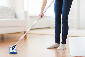 Image showing close up of woman with mop cleaning floor at home