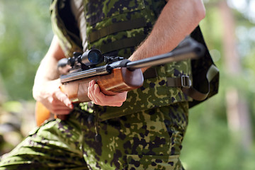 Image showing close up of soldier or hunter with gun in forest