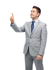 Image showing happy businessman in suit touching something