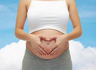 Image showing close up of pregnant woman touching her bare tummy