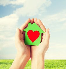 Image showing hands holding green paper house