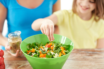 Image showing close up of happy family cooking salad in kitchen