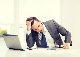 Image showing businessman with computer, papers and calculator