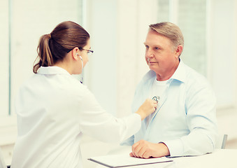 Image showing female doctor with old man listening to heart beat