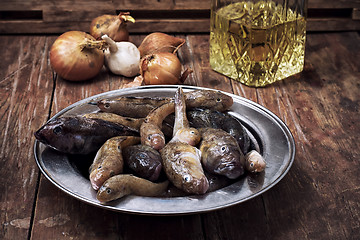 Image showing catch fish breed like in the metal plate on the table before cooking