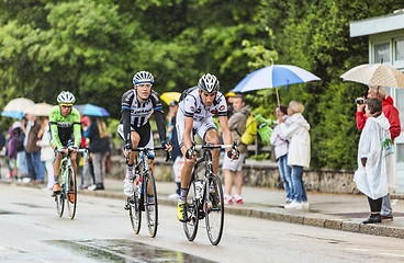 Image showing Three Cyclists Riding in the Rain