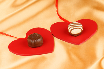 Image showing Two chocolate candies and hearts