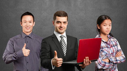 Image showing Asian team and male in suit with laptop in his hands