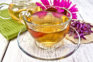 Image showing Tea Echinacea in glass cup on board with napkin