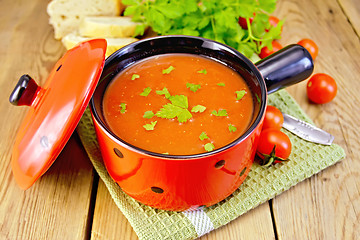 Image showing Soup tomato in red ware on board