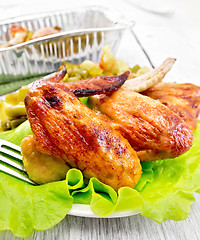 Image showing Chicken wings fried in plate on board with salad