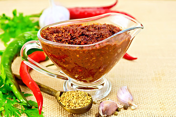 Image showing Adjika in glass gravy boat with fenugreek on sacking